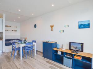 Una habitación con una mesa y armarios azules y un televisor. en La Casa del mare di Ginni e Virgi by Holiday World, en Bergeggi 21 fotos más