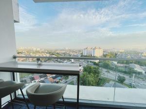 einen Balkon mit einem Tisch und Stühlen sowie eine Stadt in der Unterkunft Next to Paradigm Mall Escape JB,3BR, Up to 10 Person, in Johor Bahru