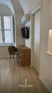a room with a desk and a chair and a window at Suite Duomo Tropea in Tropea +23 photos