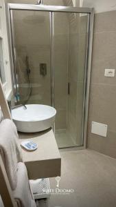 a bathroom with a shower and a white sink at Suite Duomo Tropea in Tropea