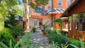 einen Innenhof eines Hauses mit Pflanzen davor in der Unterkunft Вила Фернандес in Tschernomorez