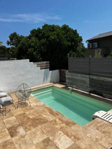 une piscine avec deux chaises et une table dans l'établissement Les Issambres, à Roquebrune-sur Argens