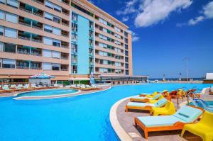 a swimming pool with lounge chairs and a hotel at Phoenicia Boutique Hotel - Adults Only in Mamaia Sat/Năvodari