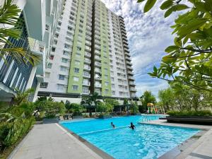 a swimming pool in front of a large building at Urban Boho Oasis1 Studio With Balcony in Davao City
