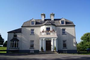 a large gray house with a white balcony at Cavangarden House in Ballyshannon