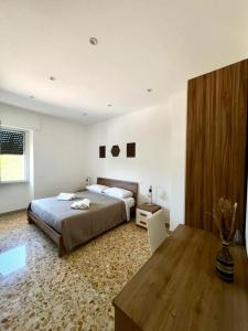 a bedroom with a large bed and a table at B&BPodere1149 in Villafranca