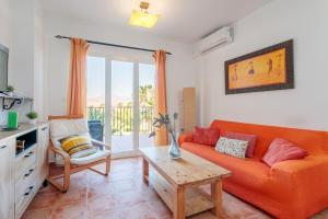 un salon avec un canapé orange et une table dans l'établissement Las Lomas de Bonalba, à Mutxamel