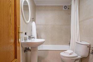 ein Badezimmer mit Waschbecken, Toilette und Spiegel in der Unterkunft Apartamento Avenida del Mar in Oviedo + 9 Fotos