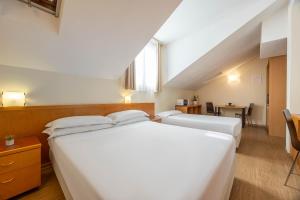 Giường trong phòng chung tại iH Hotels Milano ApartHotel Argonne Park