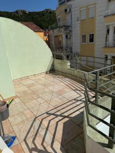 ein Gebäudeschatten auf einer Terrasse in der Unterkunft Jadran Rafailovic in Rafailovici + 2 Fotos