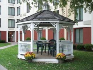 - un kiosque avec une table et des chaises dans la cour dans l'établissement Ramada by Wyndham Watertown Thousand, à Watertown