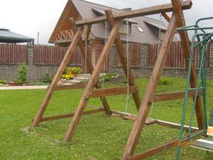 a wooden swing set in a yard at Romo sodyba in Trakai