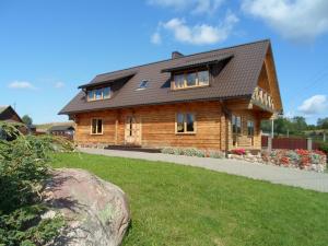 a wooden house with a gambrel roof at Romo sodyba in Trakai
