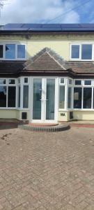 a house with white doors and windows on a brick yard at Cosy Cottage in Harvington in Harvington