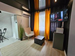 a living room with a flat screen tv and a chair at Zet Urban in Brăila