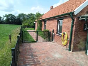 a brick house with a gate with a yellow ring on it at Huus van Dykster 45262 in Dyksterhusen