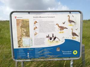 a sign in a field with ducks and geese at Huus van Dykster 45262 in Dyksterhusen