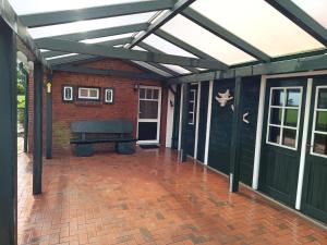 a patio with awning and a bench on a brick floor at Huus van Dykster 45262 in Dyksterhusen