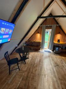 a room with a table and a tv in an attic at Cabanas na Montanha 2 in Campos do Jordão