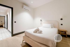 ein Schlafzimmer mit einem großen weißen Bett mit weißer Bettwäsche in der Unterkunft Diversión y confort para 10, ven a Duque de Rivas 8 E3 in Madrid