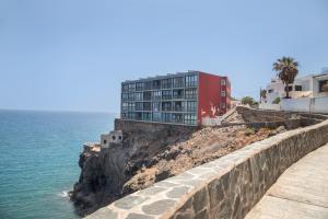 マスパロマスにあるStudio vista piscinaの海辺の断崖の上の建物