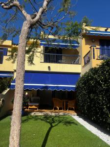 a building with chairs and a tree in front of it at Meloneras ideal in Meloneras