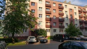 a large building with cars parked in a parking lot at L.E.C. Travel Apartments Ventspils in Ventspils