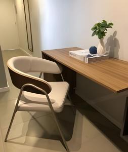 ポルト・アレグレにあるCond Belgravia Andradasの木製のテーブルと机に置かれた白い椅子