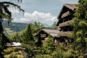 a large wooden house in the mountains with trees at Les Chalets du Mont d'Arbois & Spa, Megève in Megève