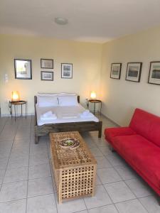a living room with a bed and a red couch at Buena Vista in Aegenitissa