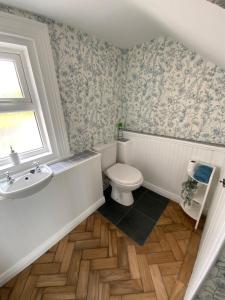 a bathroom with a toilet and a sink and a window at Period property Portrush in Portrush