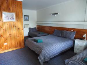 1 dormitorio con 2 camas y mesita de noche en Majestic Motel, en Horsham