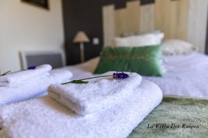 a group of towels sitting on top of two beds at La Villa Des Raspes - Séjour Spa - Adult Only in Viala-du-Tarn