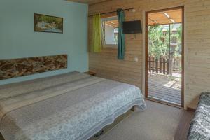 a bedroom with a bed and a sliding glass door at Pylimo slėnis in Palanga