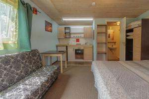 a small room with a bed and a kitchen at Pylimo slėnis in Palanga