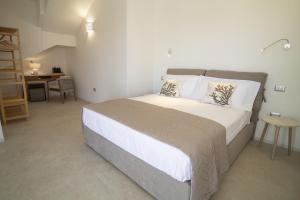 a bedroom with a large bed and a table at Borgo Bianco affittacamere in Budoni +27 photos