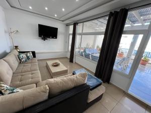 a living room with a couch and a flat screen tv at Monastir duplex with terrace in the marina in Monastir