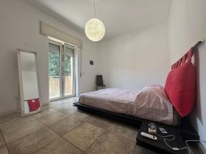 a bedroom with a bed and a large window at CASA Degli ARTISTI in Acilia