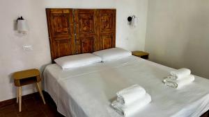 a bedroom with a white bed with towels on it at Bia Apartments Crò in Montemarcello