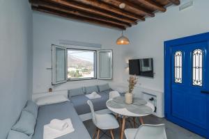 a living room with a blue couch and a table at Anemopetra in Apollonia