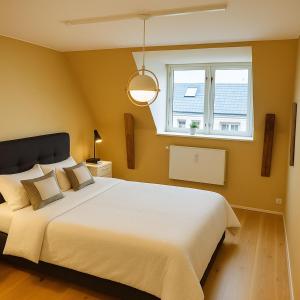 a bedroom with a large bed and a window at Central Penthouse with Private Rooftop Terrace in Copenhagen