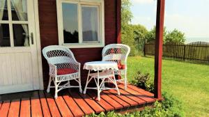 two wicker chairs sitting on the porch of a house at Domek Piaski Nad Morzem in Krynica Morska