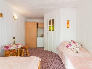 a room with two beds and a table and a kitchen at Domek Piaski Nad Morzem in Krynica Morska