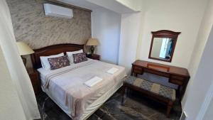 a bedroom with a bed and a mirror and a table at Villa Maslina in Petrača +15 photos