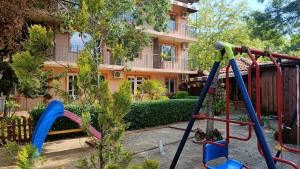 ein Spielplatz vor einem Haus in der Unterkunft Вила Фернандес in Tschernomorez