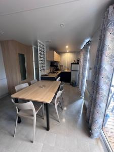 a dining room table and chairs in a kitchen at Mobil Home Premium Camping Mayotte 5 CLIM TV LV R096 in Biscarrosse