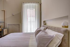a bedroom with a large bed and a large window at Piccapane Rooms 1886 in Barletta