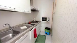 une petite cuisine avec un évier et un micro-ondes dans l'établissement Trilocale Fronte Mare-ideale Lavoratori Monaco, à Roquebrune-Cap-Martin 7 autres photos