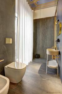 a bathroom with a tub and a toilet and a sink at Piccapane Rooms 1886 in Barletta +14 photos