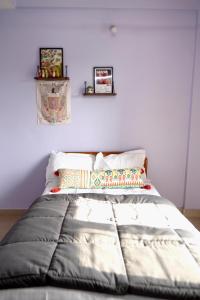 a bed in a room with a white wall at Aesthetic 2BHK, near aashima mall in Bhopal